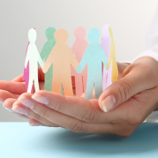 Hand holding paper cut in the shape of people