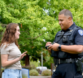 Resident talking to a police officer near a park.