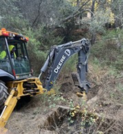 Cleaning out storm hot spot creek inlet with the backhoe