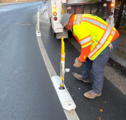 Staff fixing a damaged bike lane delineator