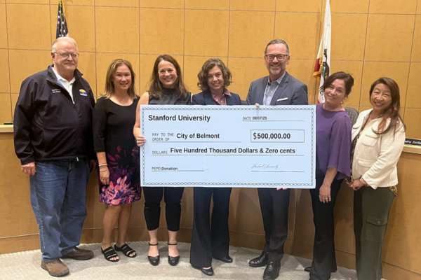 City Council holds up donation check from Stanford