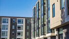 Gray and white apartment buildings in front of blue sky