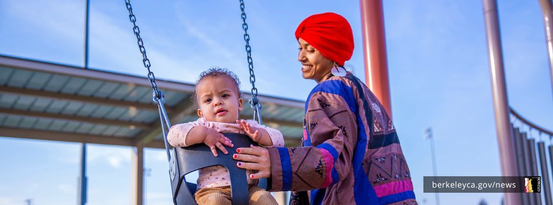 Woman pushing young child in a swing