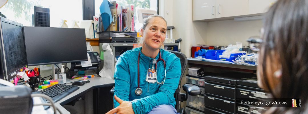 Woman wearing a stethoscope talking to a patient
