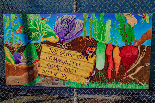 Mural that says, "We grow in community. Come root with us."