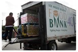 Large truck with person offloading pallets of food