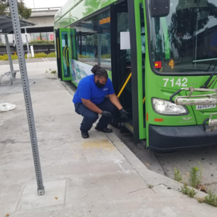 Culver City Bus and Employee kneeling with gloves on to show cleaning