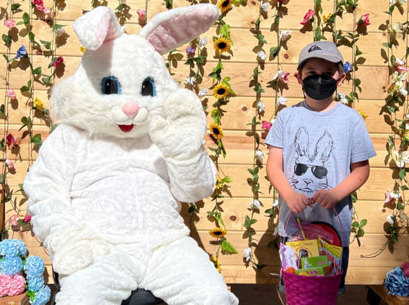 Culver City PRCS Easter Bunny alongside boy holding a basket full of chocolates and Easter eggs