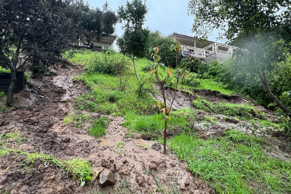 Photo of rainy conditions causing mudflow issues behind homes on Cranks Road