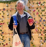 older man with city swag items and plant