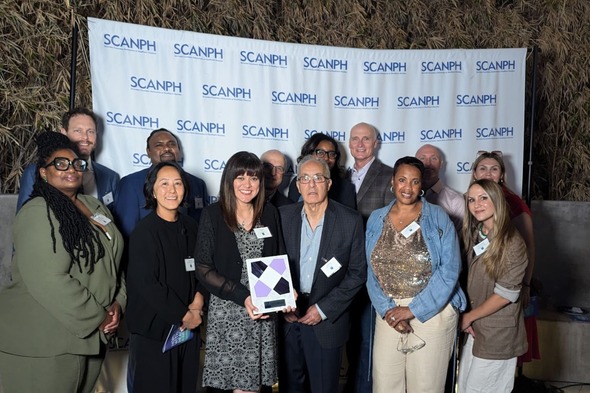 Photo of people gathering for photo with award