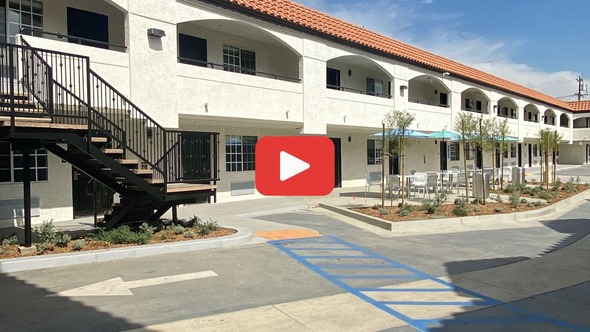 Photo of Project Homekey with play button linking to video of ribbon cutting