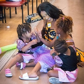 Photo of woman playing with two children