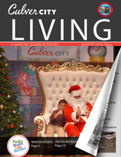 Two kids in red sit on a white throne with Santa Claus