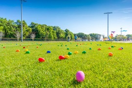 Colorful plastic eggs on field