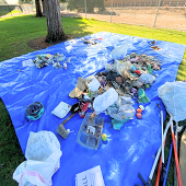 Litter collected at Regnart Creek cleanup on top of a blue tarp