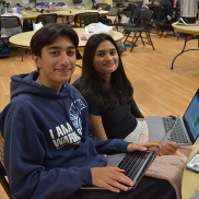 Two Hack Cupertino participants with laptops