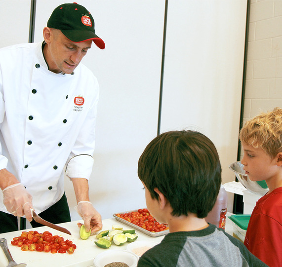 Chef showing students how to cut produce