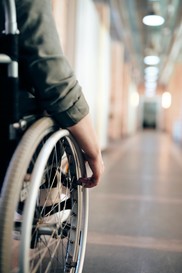 Photo of person in wheelchair going down a hallway 
