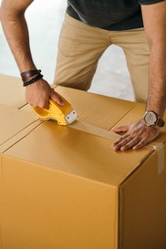 photo of person taping a box closed 