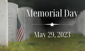 Tombstones with American Flag in front and words "Memorial Day"