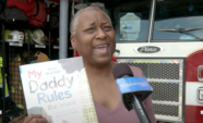 Hope Anita Smith holding her book "My Daddy Rules!" at El Segundo Fire Station