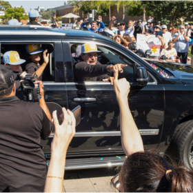 El Segundo Little League Manager Danny Boehle pointing to crowd from SUV during homecoming welcome on Main Street