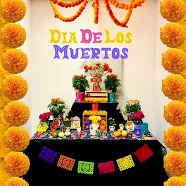 Dia De Los Muertos Altar in El Segundo Library covered in flowers, pictures, and messages