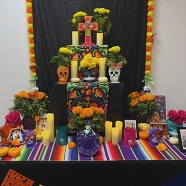 Dia De Los Muertos Altar in El Segundo Library covered in flowers, pictures, and messages