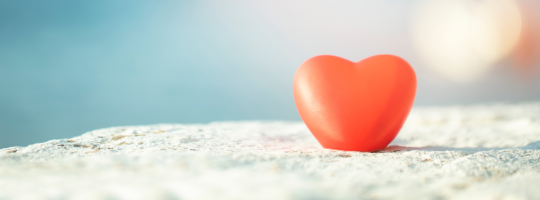 red heart in sand on beach