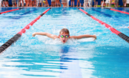 kid doing butterfly stroke in an indoor pool