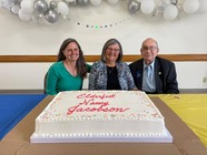 Senior Adults smiling behind Elderfest Cake