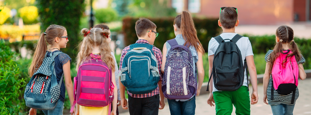 kids with backpacks walking outside together