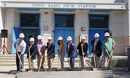City Council and local stakeholders in hard hats cermonial breaking ground in front of the Uhro Saari Swim Stadium