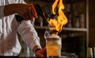 cocktail being made at John Thomas Bar with a torch to create smoke