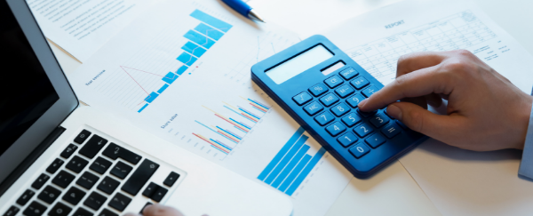 computer monitor, calculator, paper, and pen