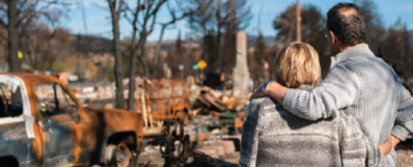 couple looking at burned down home