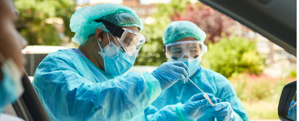 people administering vaccine to person in car