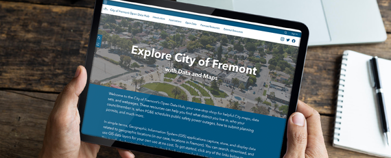 hands holding mobile device with notebook and pen