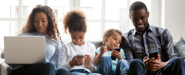 family on their devices on a couch