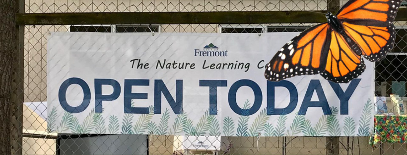 banner hanging on chain link fence and butterfly