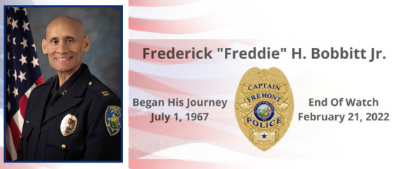 Freddie Bobbitt in police uniform with flag and Fremont Police Department Captain badge