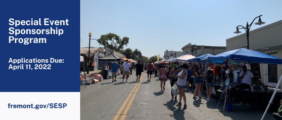 people walking in the street in front of booths at the Niles Antique Fair