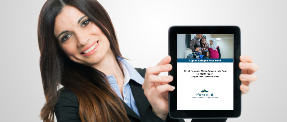 woman holding a tablet with Afghan Help fund six-month report on screen