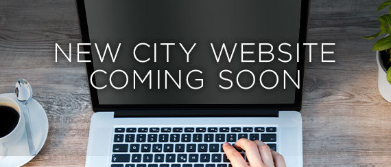hand typing on laptop with New City Website Coming Soon text