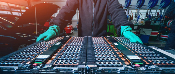 person standing in front of batteries manufacturing line