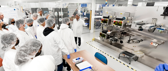 students on tour in lab wearing clean suits 