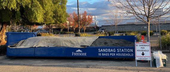 sandbag filling station with sand in rolloff bin and sandbags