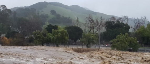 Alameda Creek overflowing with green hills in background