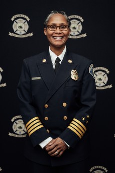 Zoraida Diaz, Fremont Fire Department standing in front of FFD backdrop with logos 